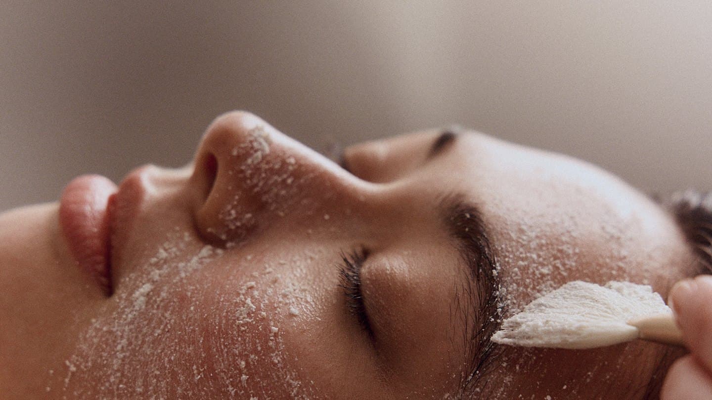 Mujer recibiendo un ritual facial holístico con exfoliación suave en Yantra
